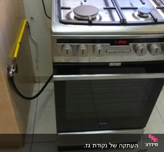 תנור גז עם כיריים מחובר לצינור גז צהוב